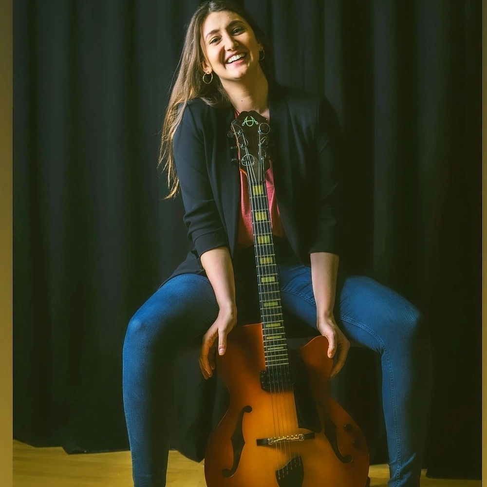 Bailey smiling with guitar for ESA-friendly online music lessons